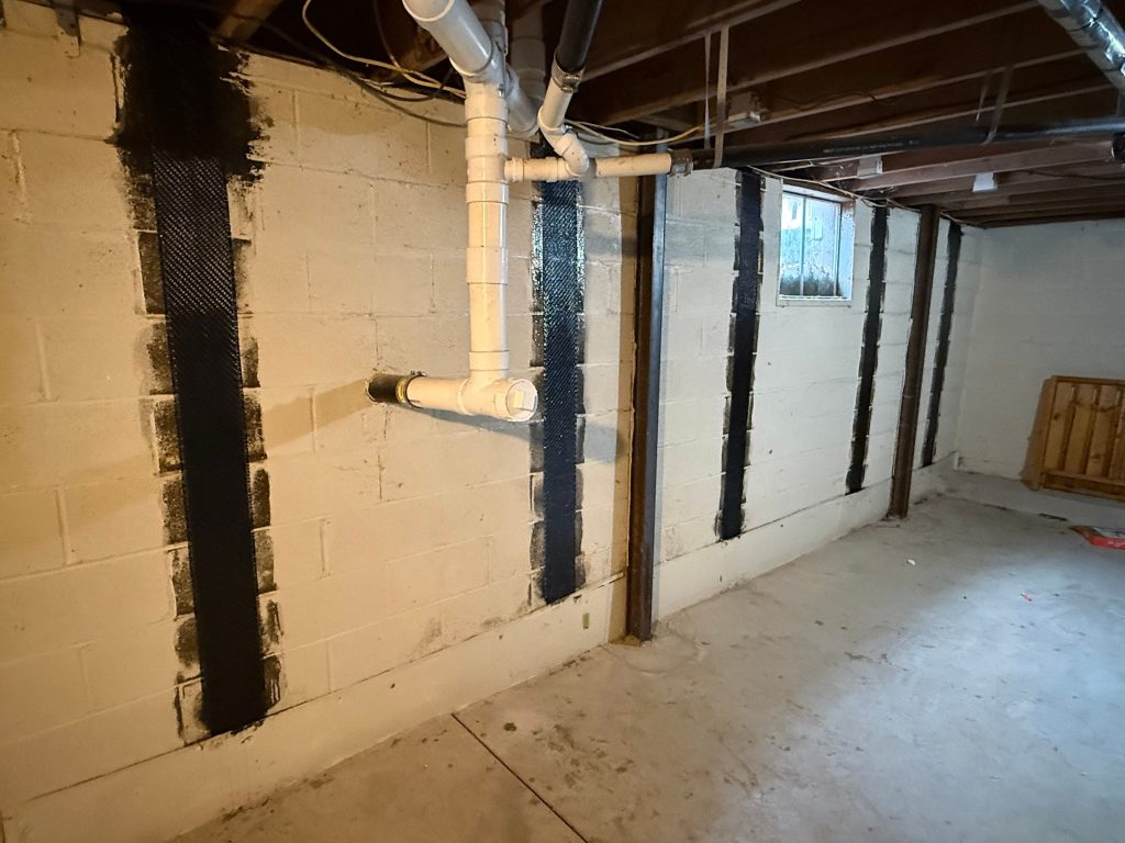 Technician installing carbon fiber straps on a bowing basement wall in Columbus, Ohio