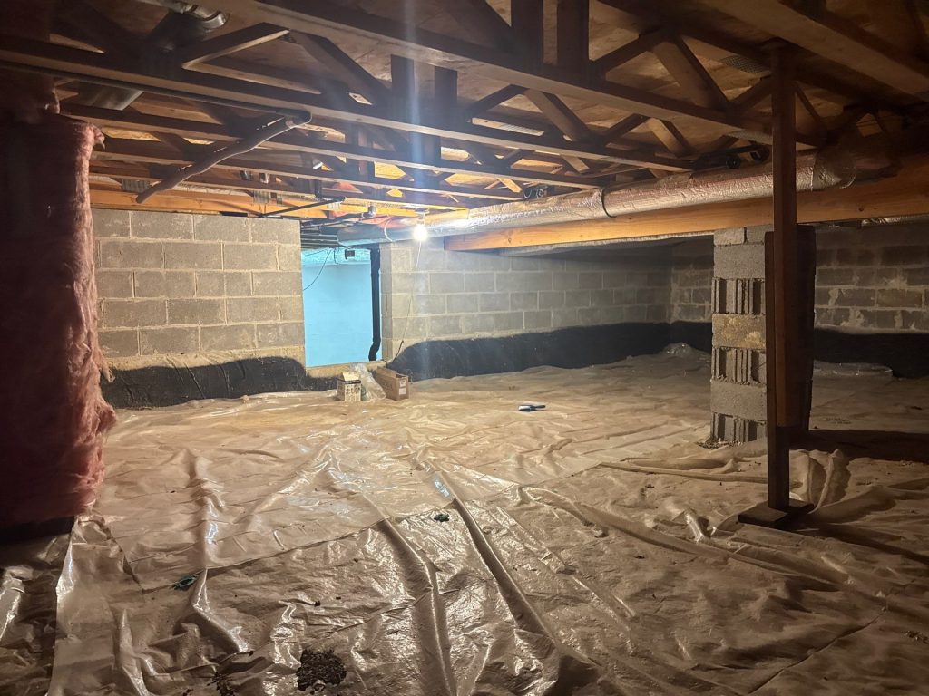 Crawlspace encapsulation in Delaware, OH with floor vapor barrier beneath exposed joists and concrete block walls
